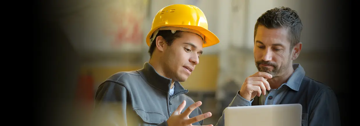 An engineer is explaining equipment operation techniques to the worker.